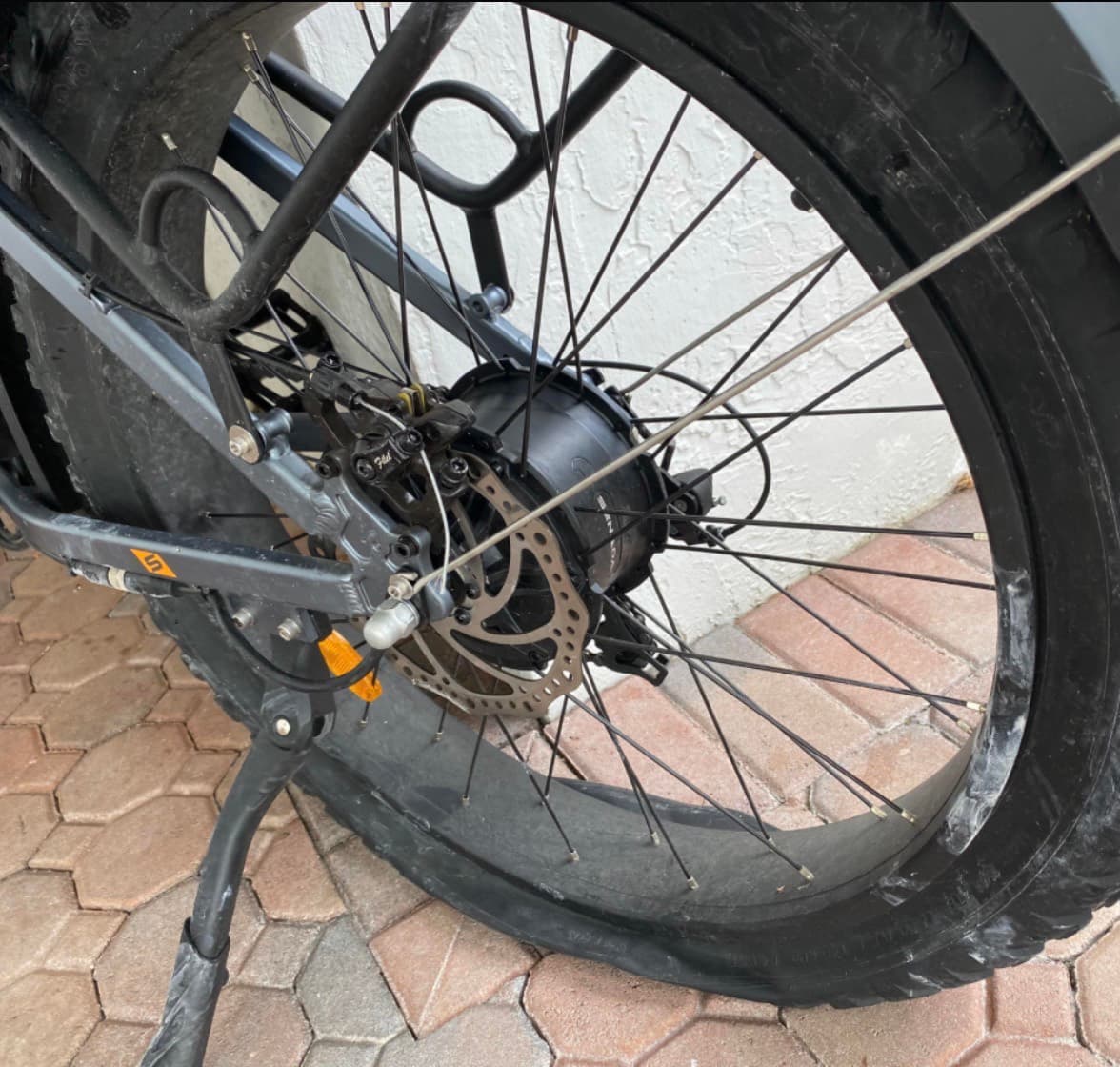 A real e-bike rear hub-motor wheel with a completely flat tire