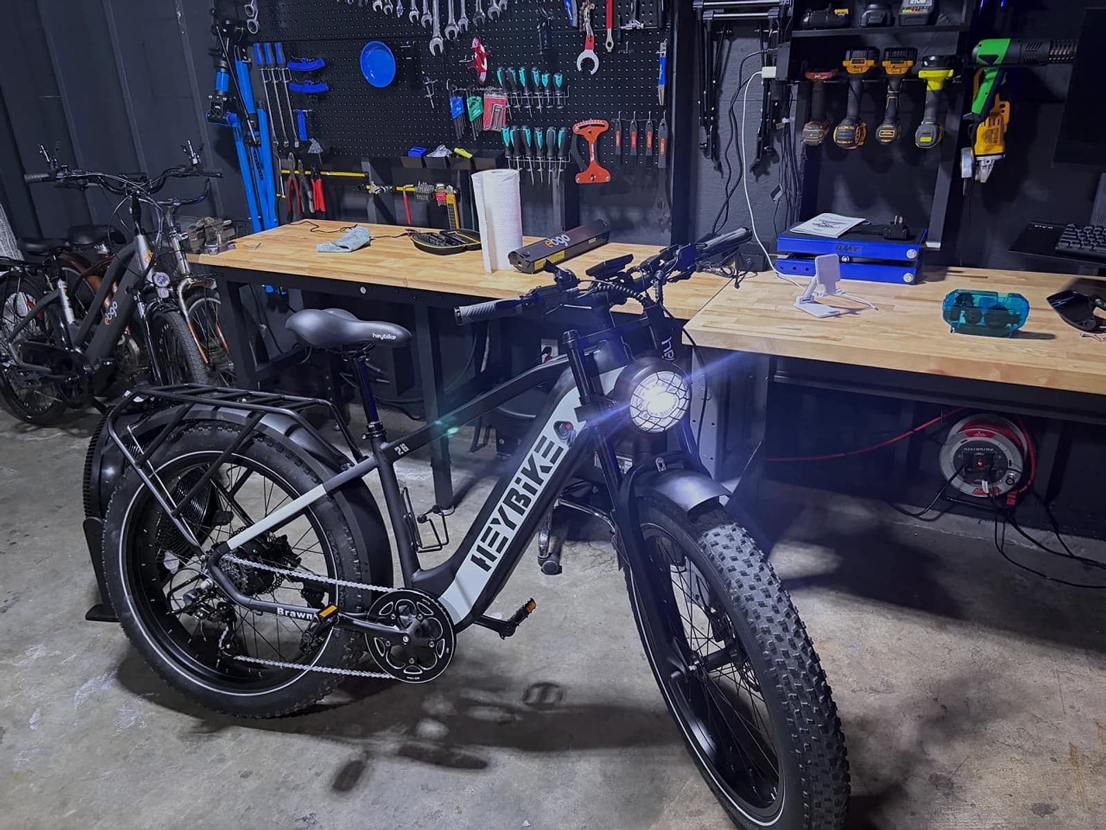 A serviceable e-bike prepared for wet-weather riding inside the Sprocket Science workshop